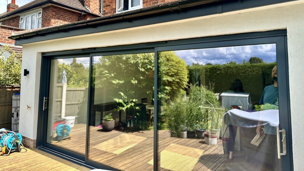 Cozy Modern Home Extension with Garden View Modern home extension with sliding glass doors and a beautiful outdoor deck for relaxation.